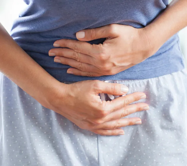 Ein Mensch hält sich die Hände vor den Bauch