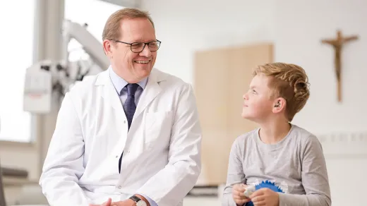 Bild von Dr. Keinztel mit einem Kind