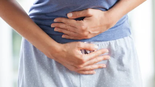 Ein Mensch hält sich die Hände vor den Bauch