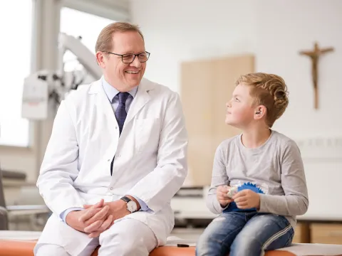 Bild von Dr. Keinztel mit einem Kind